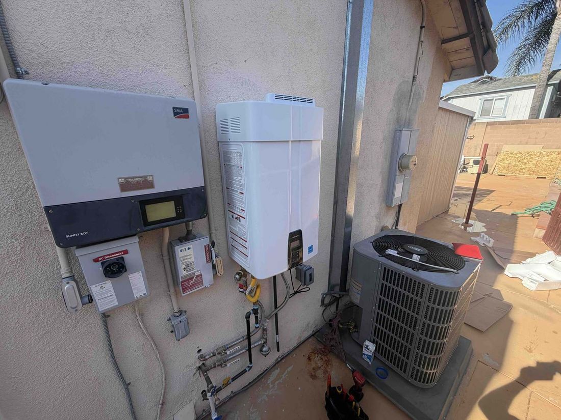 Tankless water heater installed beside a solar inverter