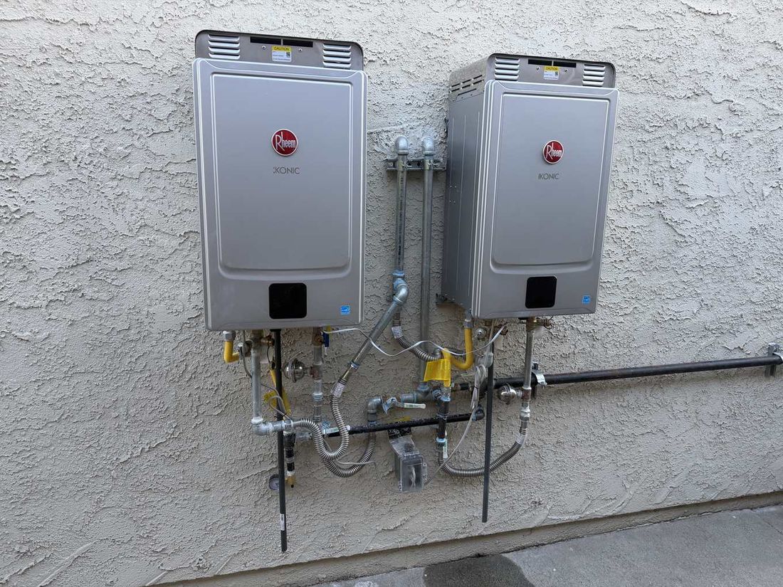 Two Rheem tankless units on an exterior wall