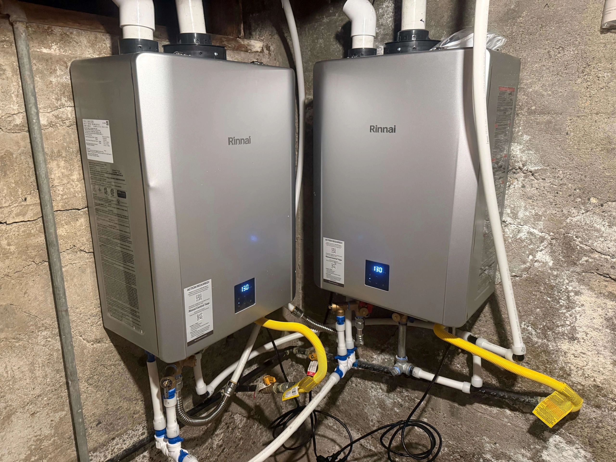 Two tankless water heaters installed side by side